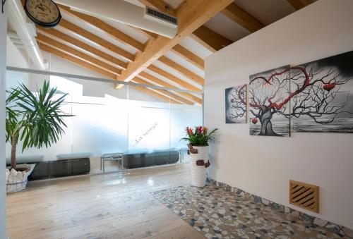 a room with a clock on the wall and plants at Hotel Luna Bianca Folgaria in Folgaria