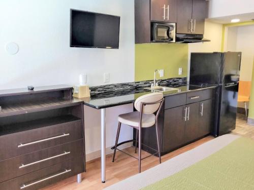 a kitchen with a desk with a sink and a microwave at Studio 6-Fresno, CA - Extended Stay in Pinedale