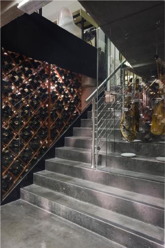 a set of stairs with a wall of wine bottles at Amosa Liège City Centre Hotel in Liège