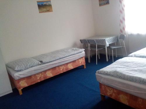 a room with two beds and a table and chairs at U nových přátel in Lichkov
