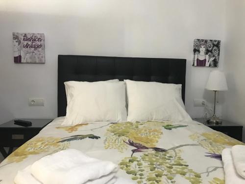 a bedroom with a bed with a black headboard at Hostal Sabana in San Martín del tesorillo