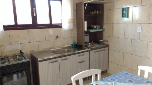 a small kitchen with a sink and a stove at Canto da Praia in Itajubá