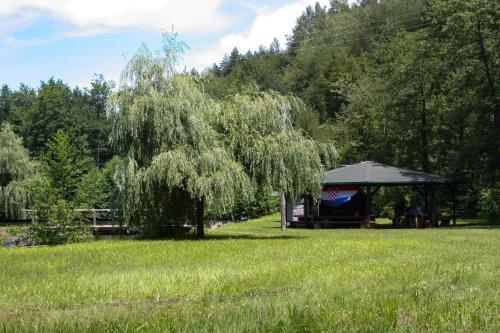 a gazebo in a field with a tree at Robinson camp "Zeleni mir" in Josipdol