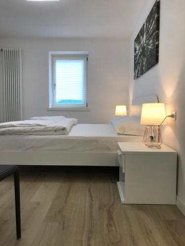 a bedroom with a bed and a table with a lamp at Trentino Apartments - Casa ai Tolleri in Folgaria