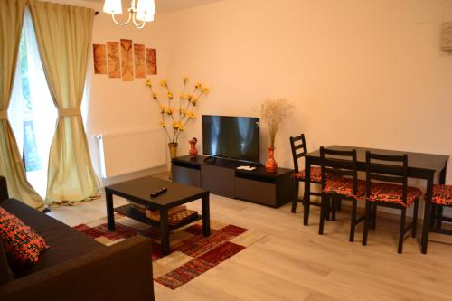 ein Wohnzimmer mit einem Tisch und einem Esszimmer in der Unterkunft Apartament Pheonix in Buşteni