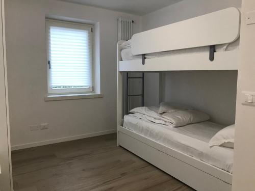 a bedroom with a bunk bed and a window at Trentino Apartments - Casa ai Tolleri in Folgaria