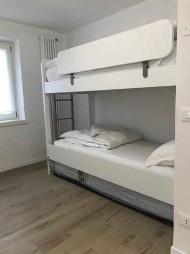 two bunk beds in a room with a wooden floor at Trentino Apartments - Casa ai Tolleri in Folgaria
