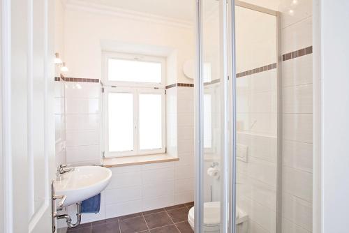 a white bathroom with a sink and a toilet at Bayerischer Hof in Ingolstadt