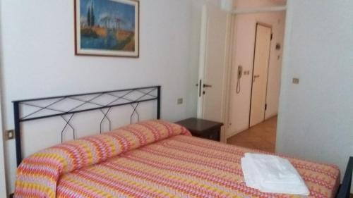 a bedroom with a bed with a orange and yellow blanket at CASA CENTRO STORICO RIMINI in Rimini