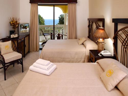 a hotel room with two beds and a balcony at Lifestyle Tropical Beach Resort & Spa All Inclusive in San Felipe de Puerto Plata