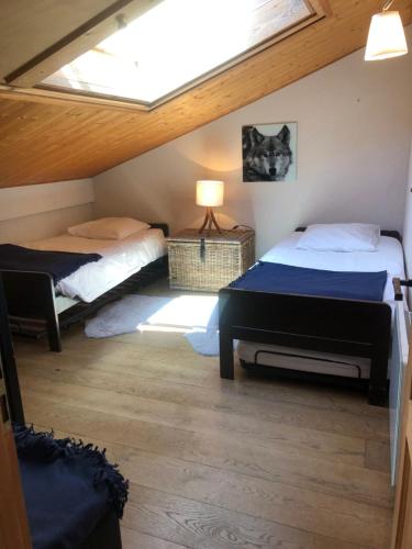 a attic bedroom with two beds and a skylight at Appartement du Petit Bois in Megève