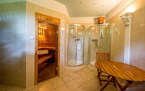 a bathroom with a shower and a wooden table at Penzion Sonja in Vyšné Ružbachy