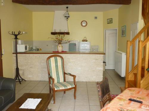 a kitchen with a counter and a chair in a room at Gîte Le Logis de Faugerit in Frontenay-Rohan-Rohan