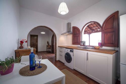 una cocina con una mesa con una botella. en Los Torres II, en Fuencaliente de la Palma