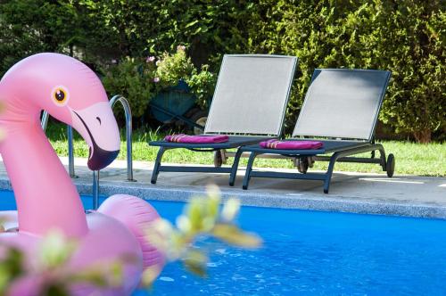 two chairs and a pink flamingo next to a pool at Villa Serenity in Porto Rafti