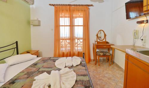 een slaapkamer met een bed met handdoeken erop bij Pension Andromeda in Patitiri