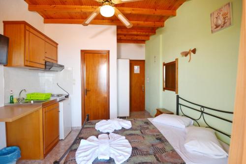 eine Küche mit einem Bett und einem Waschbecken in einem Zimmer in der Unterkunft Pension Andromeda in Patitiri
