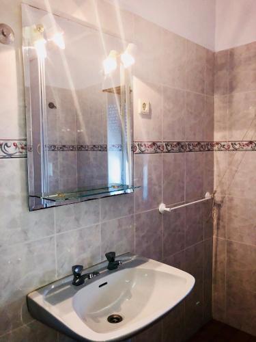 ein Badezimmer mit Waschbecken und Spiegel in der Unterkunft Suites Do Pinhal in Proença-a-Nova
