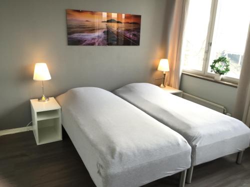 2 camas en una habitación con 2 lámparas en Masthuggsterrassens Hostel, en Gotemburgo