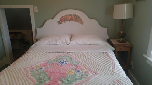 a bed with a pink and white quilt on it at 2 bedroom Wiffen Cottage in Port Albert