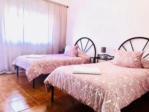 ein Schlafzimmer mit zwei Betten und einem Fenster in der Unterkunft Suites Do Pinhal in Proença-a-Nova