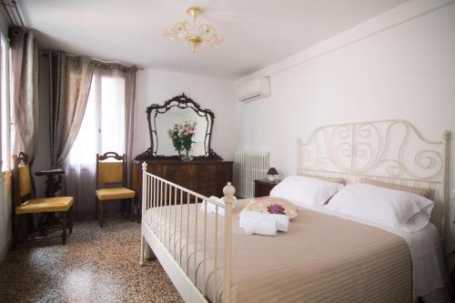 een slaapkamer met een wit bed en een spiegel bij Cà Lina in Venetië