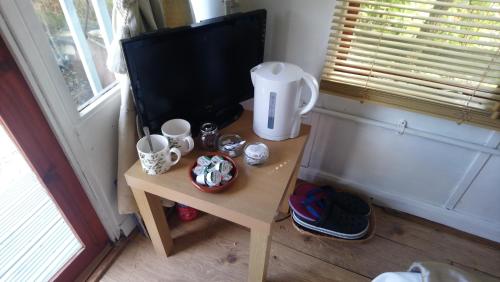 a small table with cups and mugs on it at Rebels Hide -Self check in rooms in Penrith