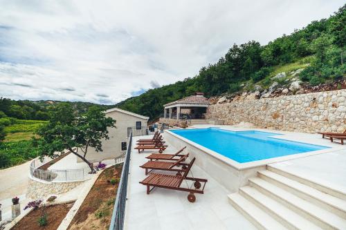 Villa con piscina y algunas sillas en Luxury Villa Borak, en Imotski