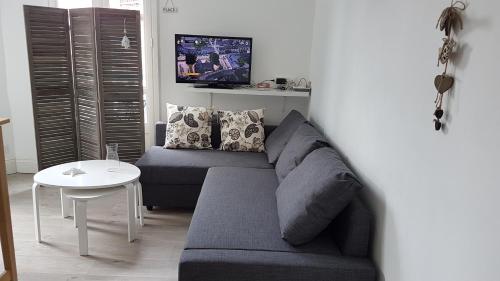 a living room with a couch and a table at 100 m de la mer, Sauna, Wifi in Mers-les-Bains