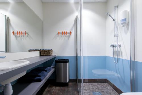 ein Bad mit einer Glasdusche und einem Waschbecken in der Unterkunft RS Noatun in Horten