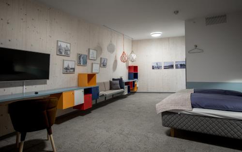 a room with a tv and a bed and a couch at RS Noatun in Horten