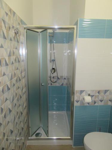 La salle de bains est pourvue d'une douche avec une porte en verre. dans l'établissement Il Sogno di Calipso, à Amendolara