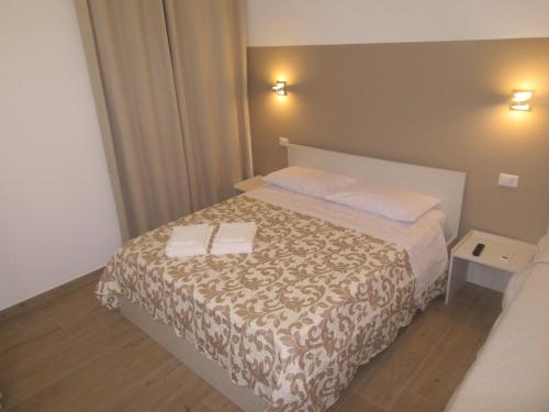 a bedroom with a bed with two towels on it at Il Sogno di Calipso in Amendolara