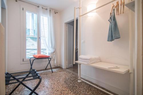 een kamer met een stoel en een raam bij Cà Lina in Venetië