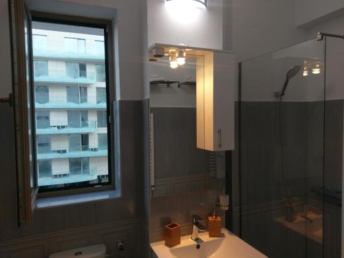 ein Badezimmer mit Waschbecken, Spiegel und Fenster in der Unterkunft Apartament Loft Beach SummerlandRomania in Mamaia