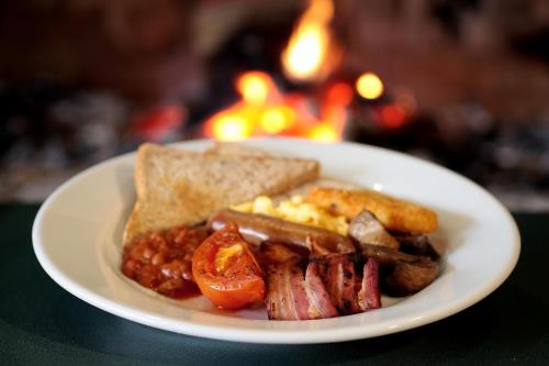 a plate of food with meat and eggs and toast at Swiss-Belresort Coronet Peak in Queenstown