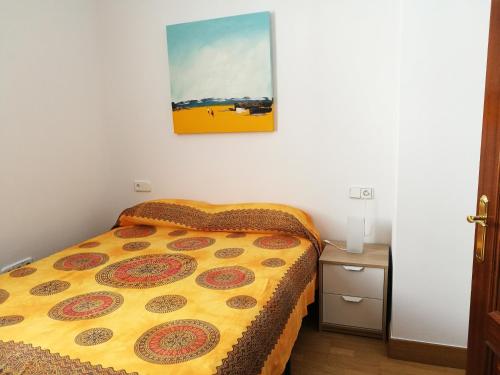 een bed in een kleine kamer met een foto aan de muur bij Apartamento Aldama en el centro de Sanlúcar de Barrameda in Sanlúcar de Barrameda
