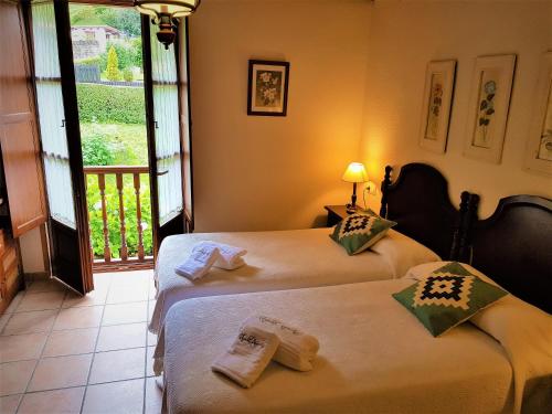 two beds in a room with a balcony at Trisqueles y Buganvillas in Villaviciosa