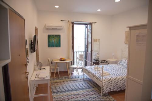 Habitación pequeña con cama y mesa pequeña. en Casa Miele Ortigia, en Siracusa