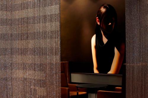 a woman standing in front of a flat screen tv at The Fullerton Hotel Sydney in Sydney