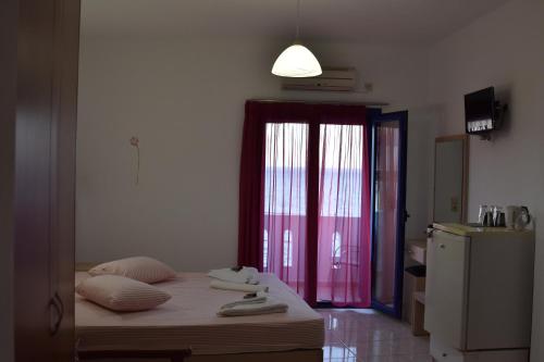 a bedroom with a bed and a dresser at Paralia guest house in Agia Roumeli