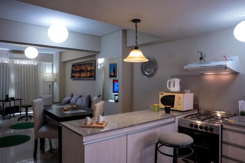 a kitchen and living room with a stove and a counter top at Apart Bicentenario in San Miguel de Tucumán
