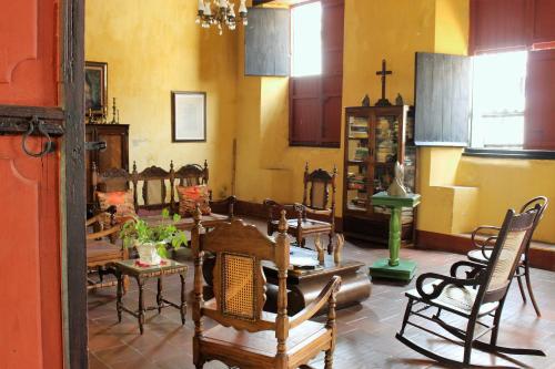 a room with tables and chairs and a cross on the wall at CASA SINNING-año1637 in Mompos