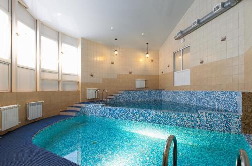 uma grande piscina com azulejos azuis num edifício em Hotel House of the Hunter em Toksovo