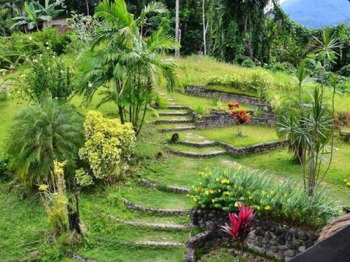 a garden with stone steps and flowers and plants at Bambua Nature Cottages in Puerto Princesa City