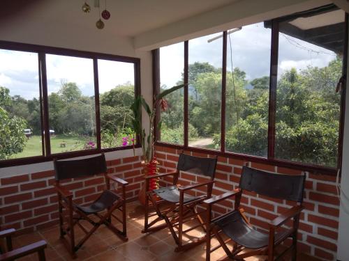 a group of chairs in a room with windows at Hostal Pachamama in San Agustín
