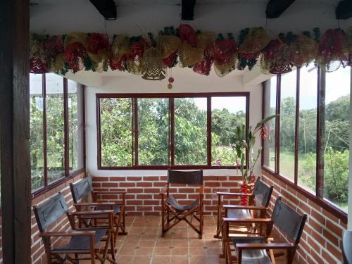 a room with tables and chairs and windows at Hostal Pachamama in San Agustín