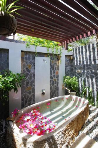 a garden with a large tub filled with flowers at Pandanus Resort in Mui Ne