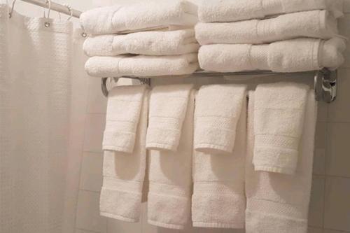 a bunch of towels on a rack in a bathroom at 2-Bedroom Apartment #30A by Amazing Property Rentals in Gatineau