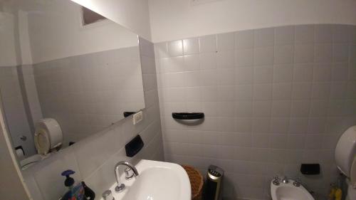 a bathroom with a sink and a toilet and a urinal at San Martin 900 con estacionamiento in Cipolletti